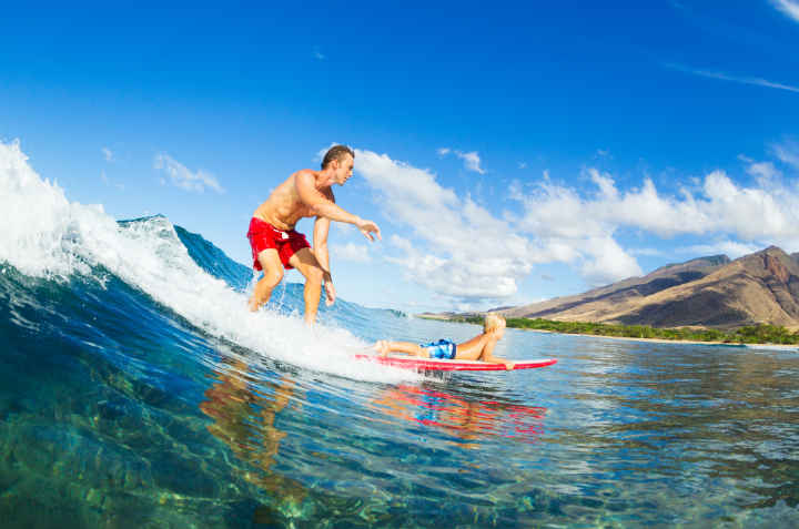 Father and son surfing a wave together. 